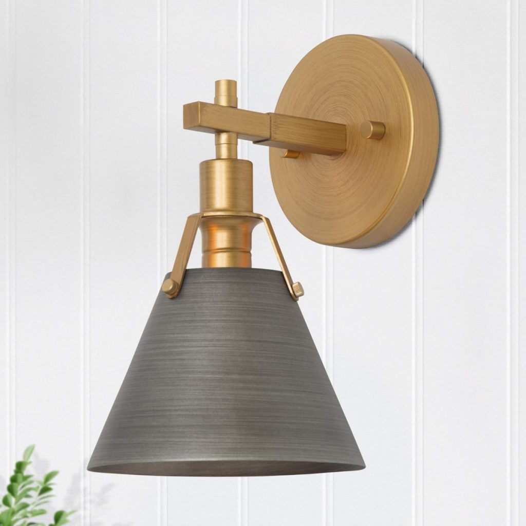 A wall-mounted sconce with a round brass base and arm, featuring a downward-facing, dark gray conical shade against a white paneled wall.