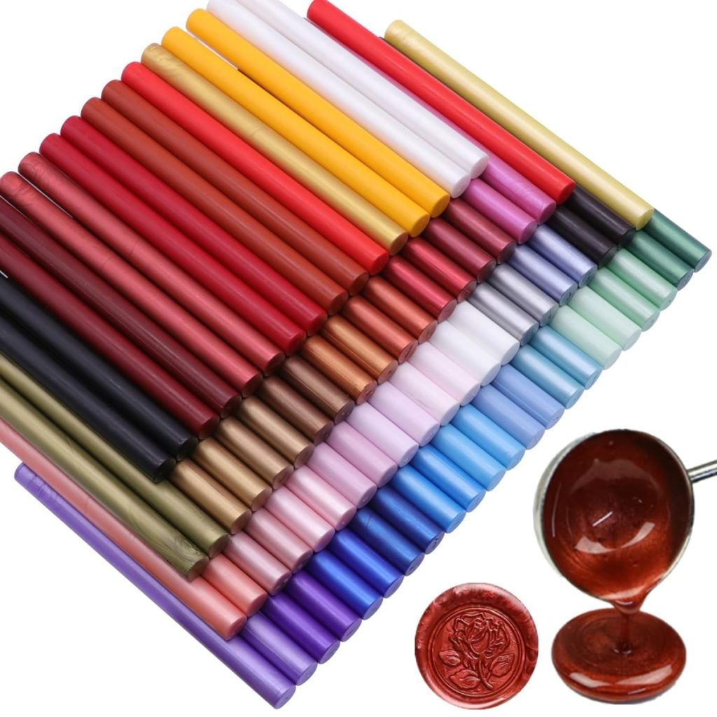 A neatly arranged set of colorful wax sealing sticks in various shades, with a spoon of melted wax and a finished wax seal beside them, perfect for creating elegant wax seals.