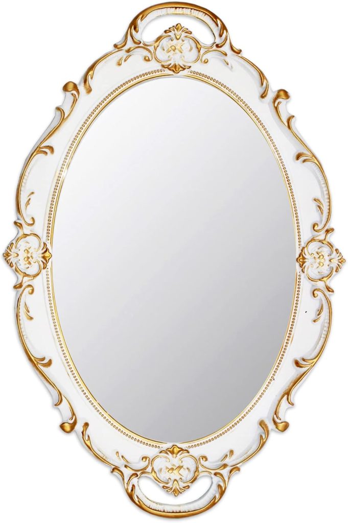 Ornate oval coastal mirror with a white and gold decorative frame, featuring intricate floral and scroll designs.