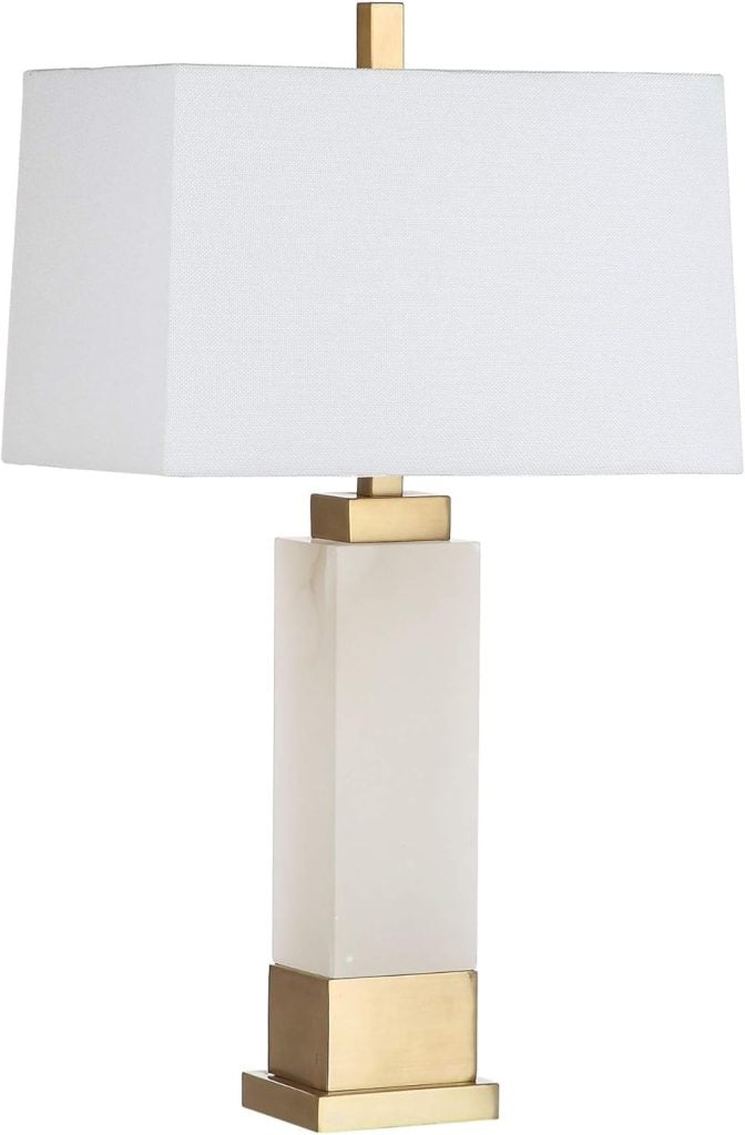 A table lamp with a rectangular white lampshade and a gold and white rectangular base.