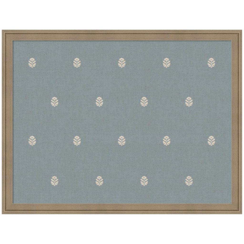 A framed blue fabric panel with evenly spaced small white leaf motifs arranged in a grid pattern.