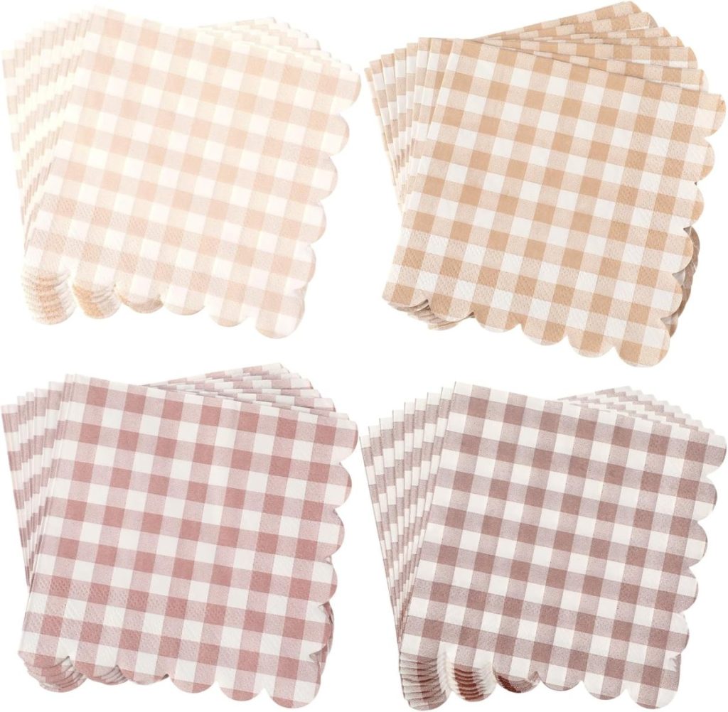 Four stacks of square, scalloped-edge napkins featuring gingham check patterns in beige and brown tones, as curated by Theo of Golden Book Club, are displayed against a white background.