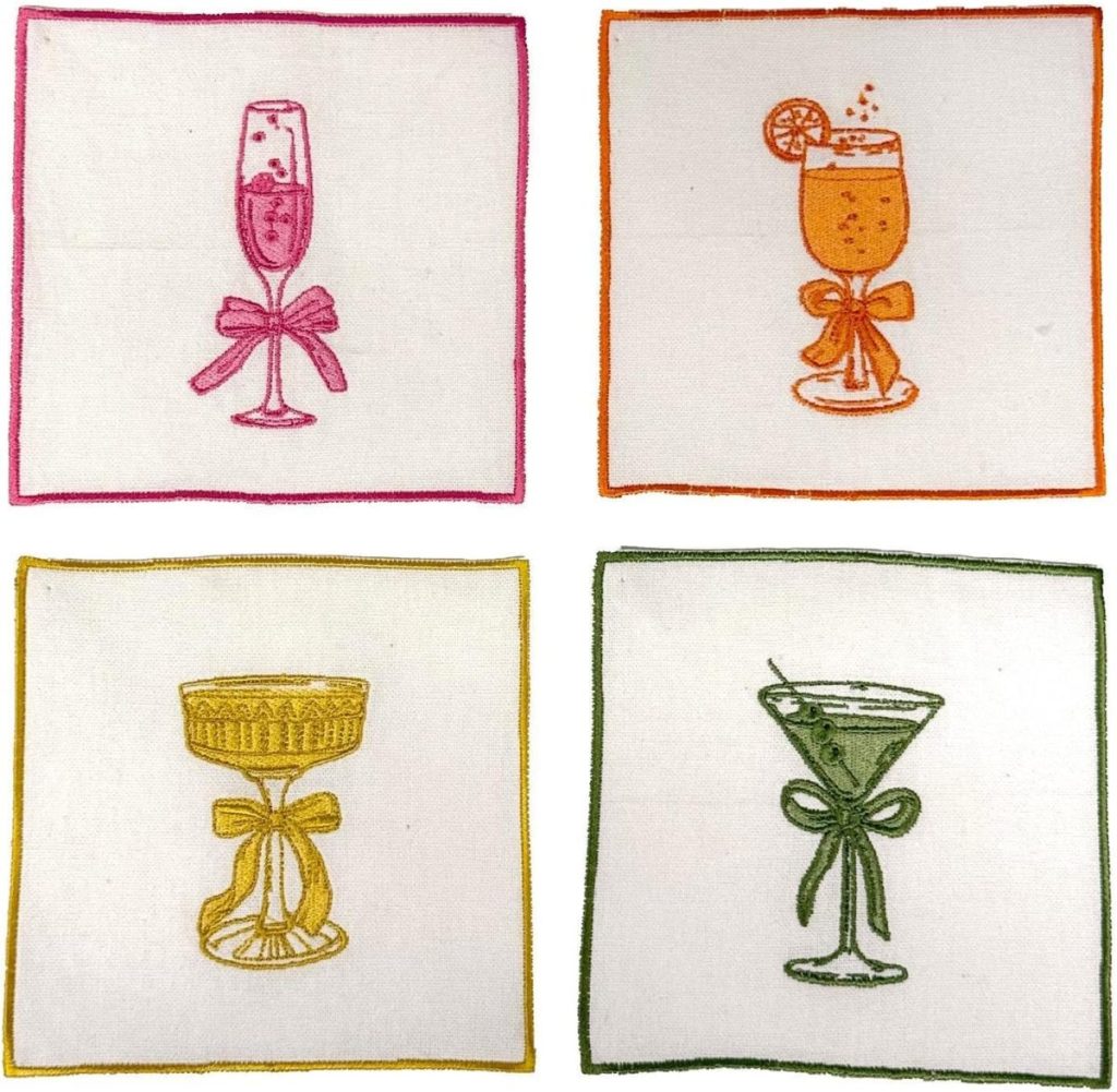These Embroidered Cocktail Napkins feature four white napkins, each adorned with a cocktail glass and bow, outlined in pink, orange, yellow, and green.