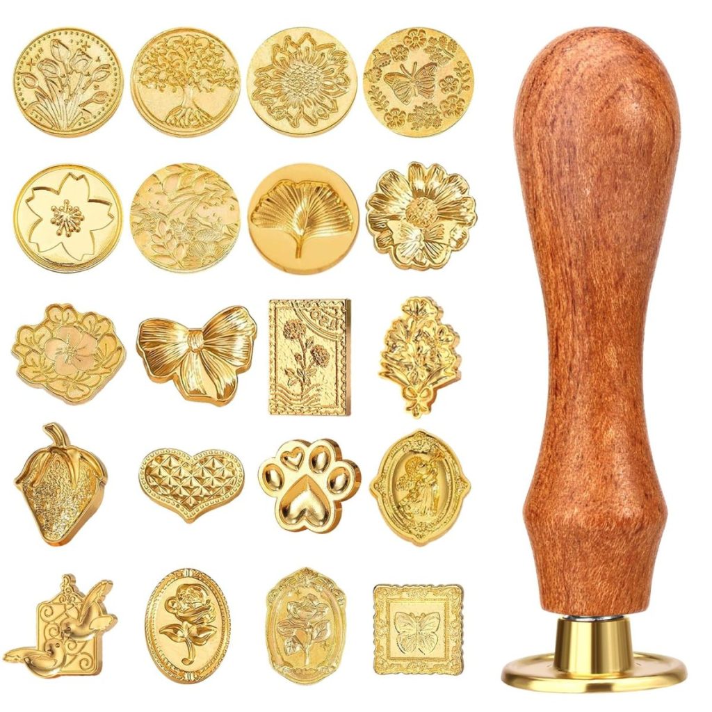 A collection of 20 gold wax seals with various designs and a wooden handle, beautifully arranged on a white background.