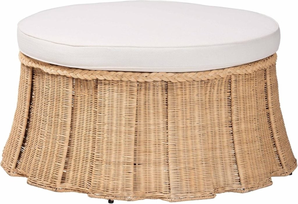 Round wicker ottoman with a white cushioned top and pleated woven skirt design.