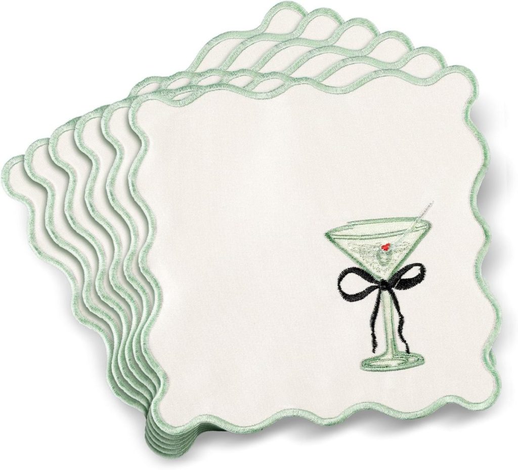 A stack of Embroidered Cocktail Napkins featuring green scalloped edges, each adorned with a martini glass, olive, and a black bow for a stylish touch.