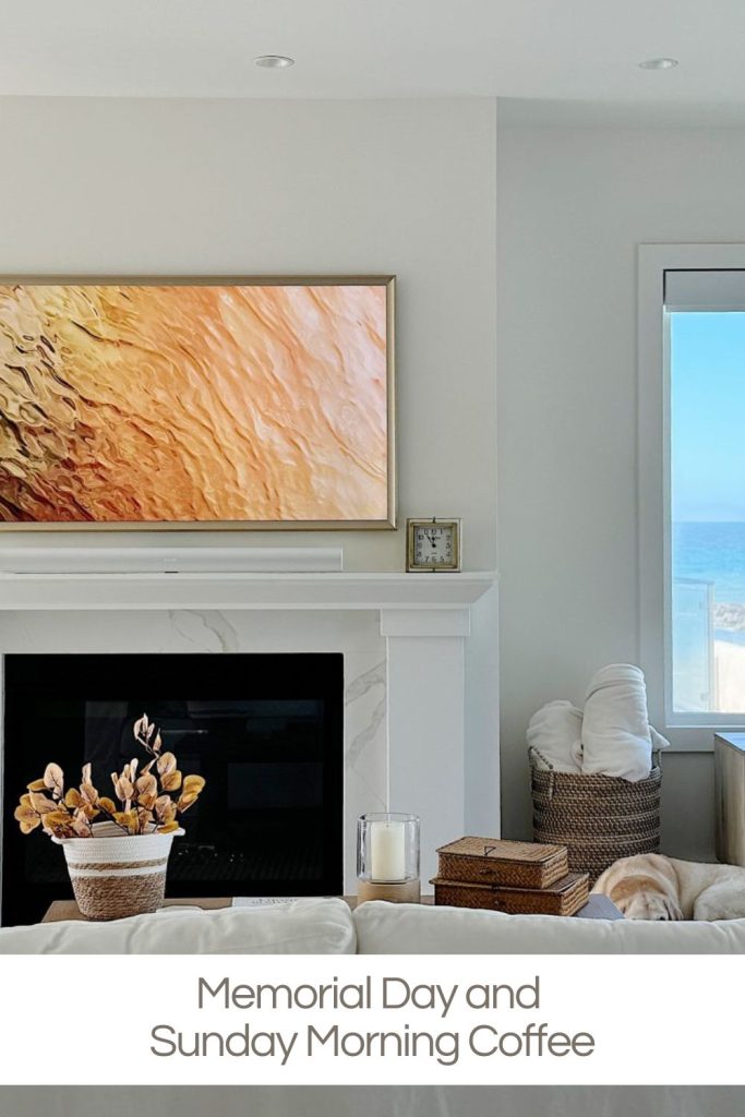 A living room with a white mantel, abstract wall art, a potted plant, and a window showing an ocean view. Text reads: "Memorial Day and Sunday Morning Coffee.