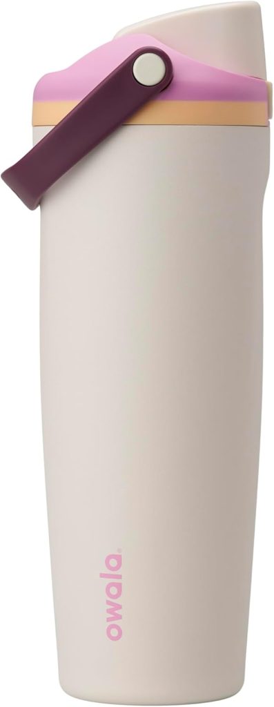 A beige Owala travel tumbler with a pink and purple lid and a purple carrying handle, standing upright against a white background.
