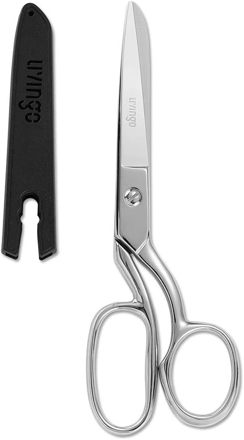 Silver metal scissors with large finger holes placed next to a black plastic protective blade cover on a white background.