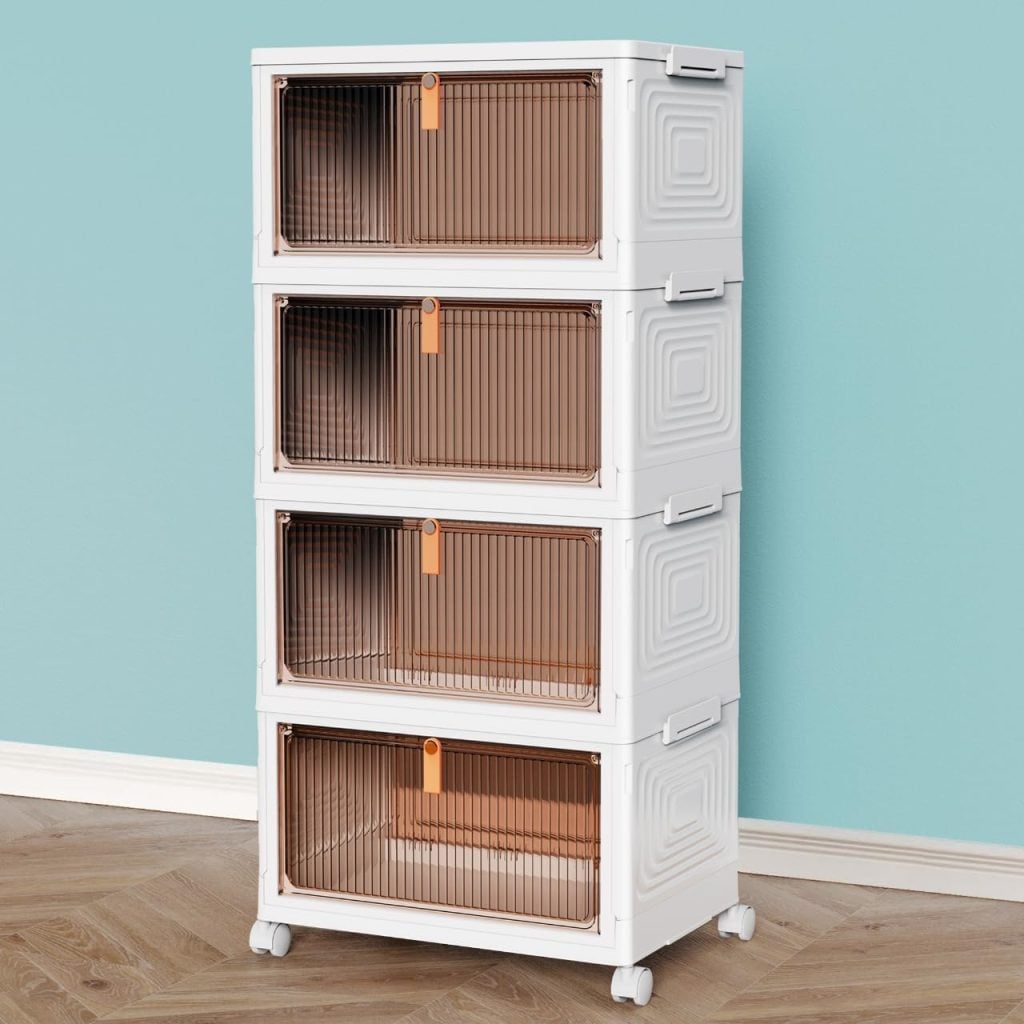 A four-tier white plastic storage unit with brown transparent front doors and orange handles, set on wheels, positioned against a light blue wall on a wooden floor.