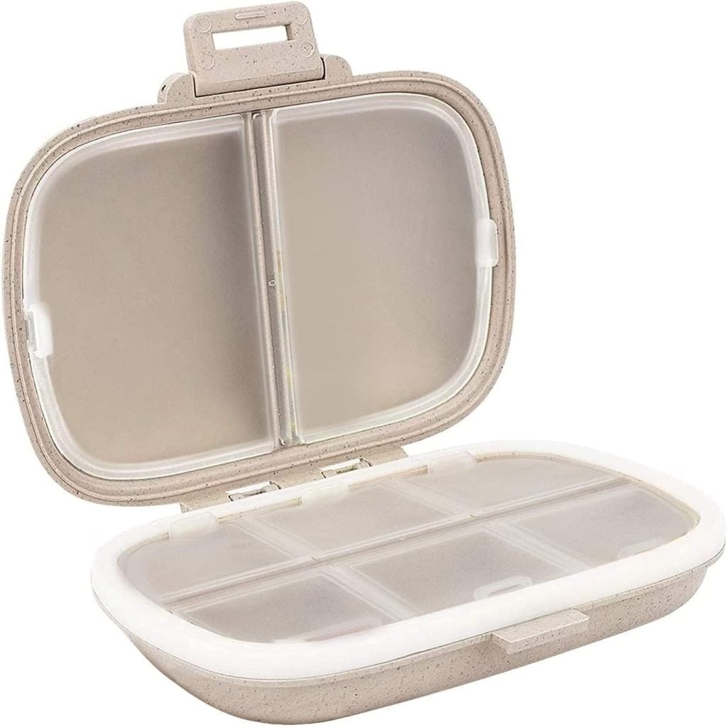 A beige plastic bento-style lunchbox with a hinged lid is open, revealing two inner compartments sealed with a transparent plastic cover.