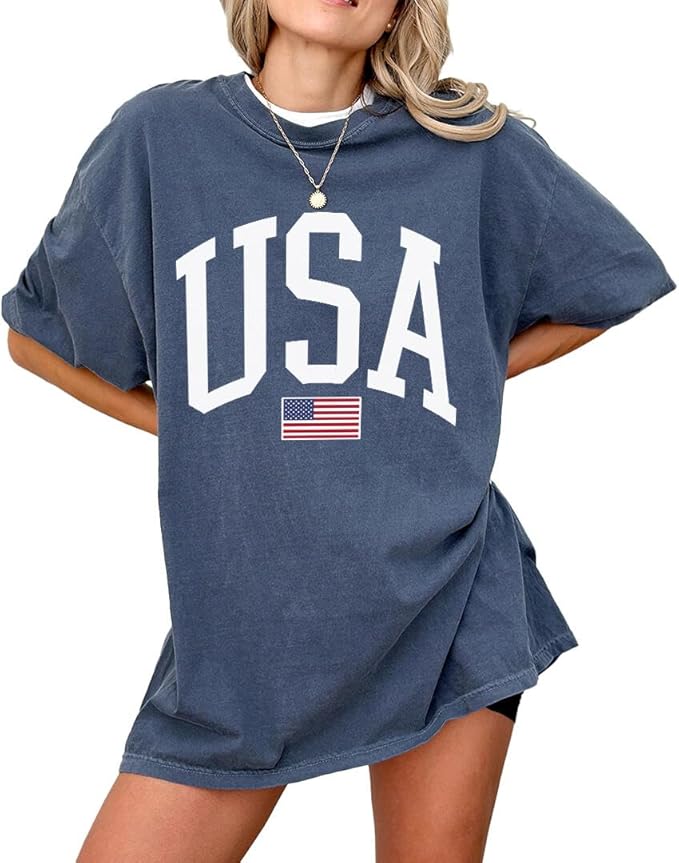 A person wearing an oversized blue T-shirt with "USA" and an American flag printed on the front.