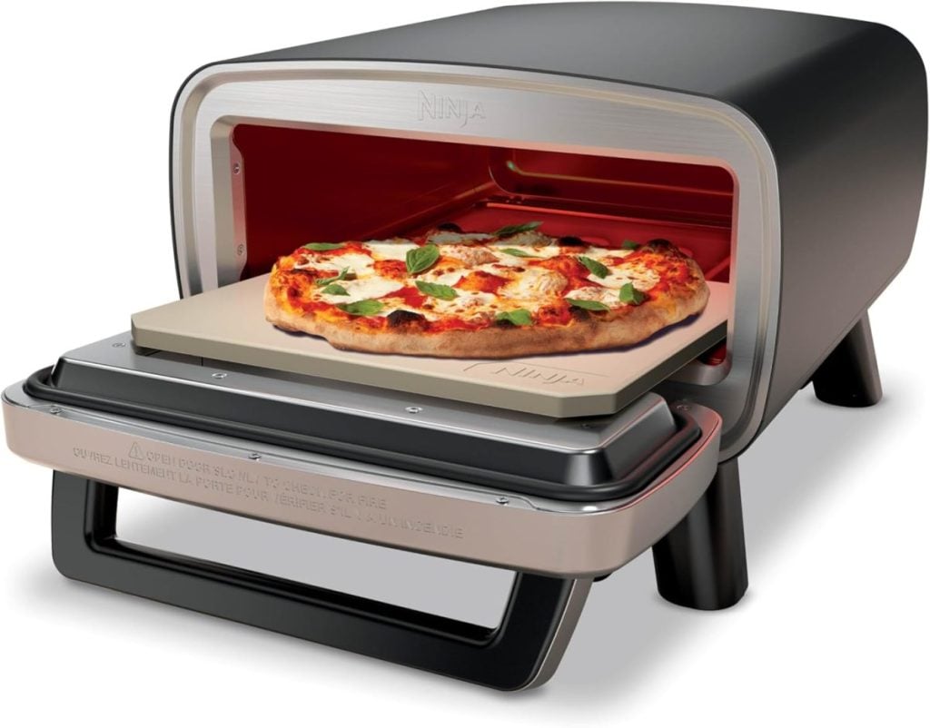 A countertop pizza oven with an open door, showing a cooked pizza topped with cheese, tomato, and fresh basil inside on a pizza stone&mdash;an ideal Amazon Father's Day gift for the pizza-loving dad.