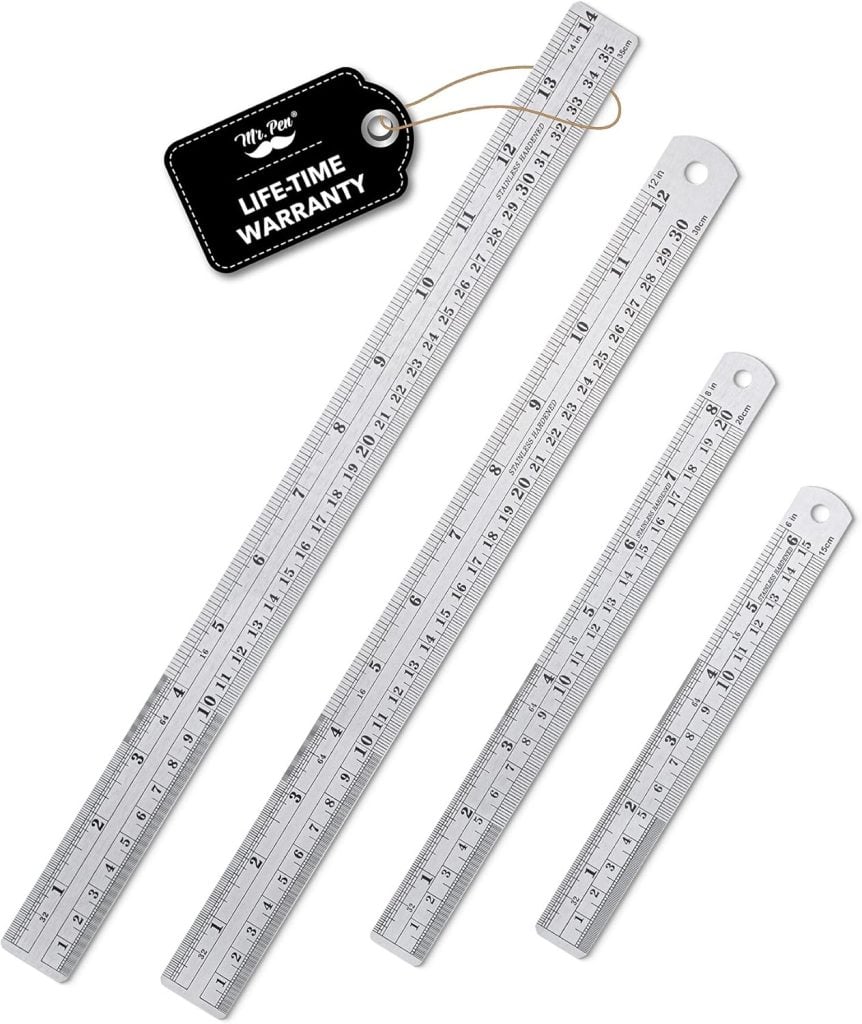 Four metal rulers of varying lengths are displayed side by side, each with measurement markings in centimeters and inches; a tag mentions a lifetime warranty.