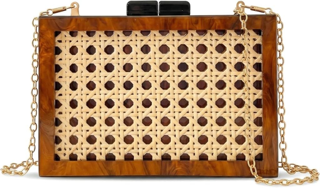 A rectangular clutch bag with a tortoiseshell frame, woven cane front panel, black clasp, and gold chain strap.