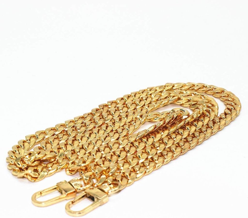 A gold-toned metal chain with clasps at both ends, laid out on a white surface.
