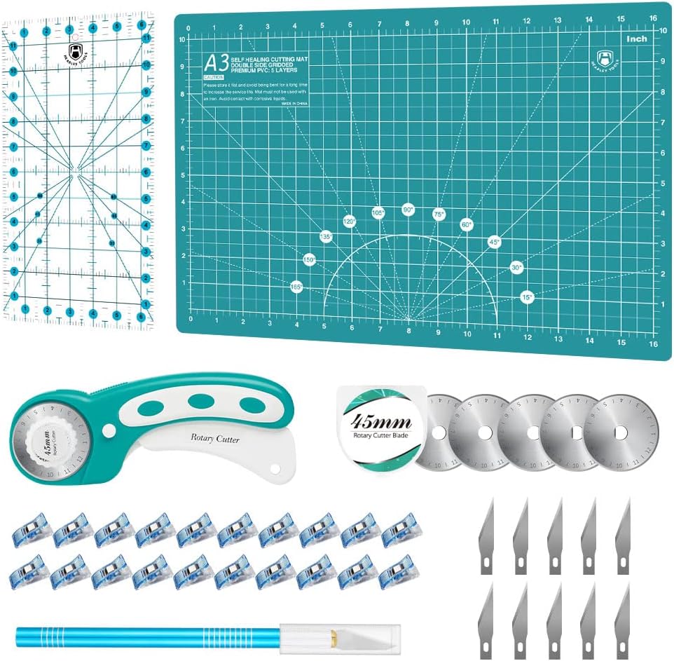 A set of quilting tools including a cutting mat, rotary cutter, ruler, extra blades, clips, craft knife, and replacement knife blades arranged neatly.