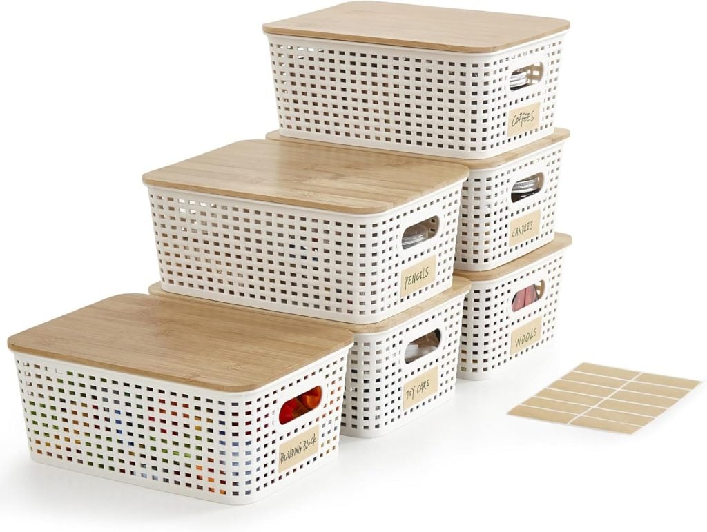 Six white plastic storage bins with wooden lids are stacked, each with a label on the front. Blank label stickers are shown beside the bins.