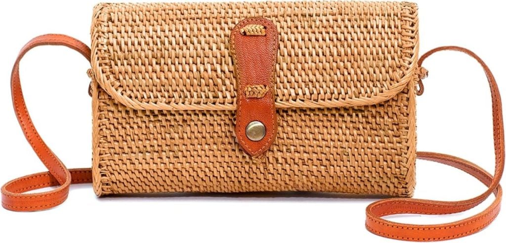 Rectangular woven straw crossbody bag with a brown leather strap and a leather flap closure featuring a metal button.