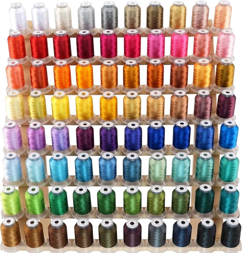 Rows of thread spools in a wide variety of colors, arranged in a grid pattern, ready for use with an embroidery machine.