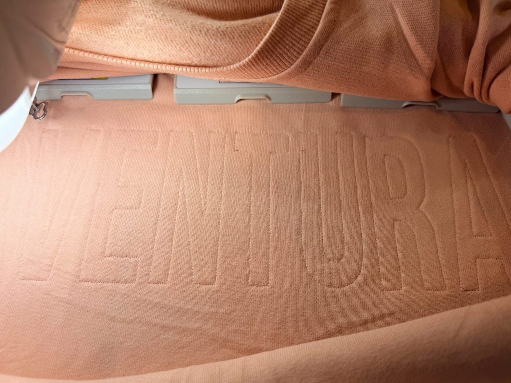 Peach-colored fabric with the word "VENTURA" embossed in large, raised letters.