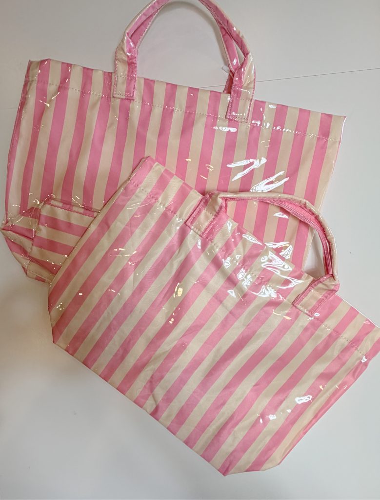 Two pink and white striped tote bags with handles are placed overlapping on a white surface.