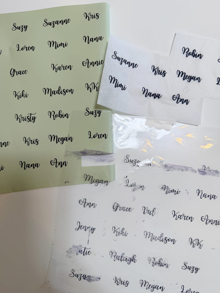 Sheets of paper with various female names printed in black script font; some names appear smudged or partially erased.
