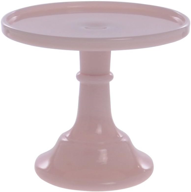 A pink ceramic pedestal cake stand with a round, flat top and a wide, stable base, perfect for displaying treats like Strawberry Shortcake Ice Cream.