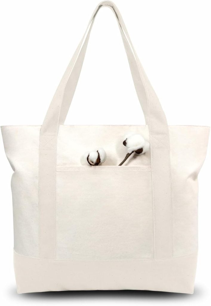 A plain white canvas tote bag with two cotton stems placed in its front pocket, photographed against a white background.