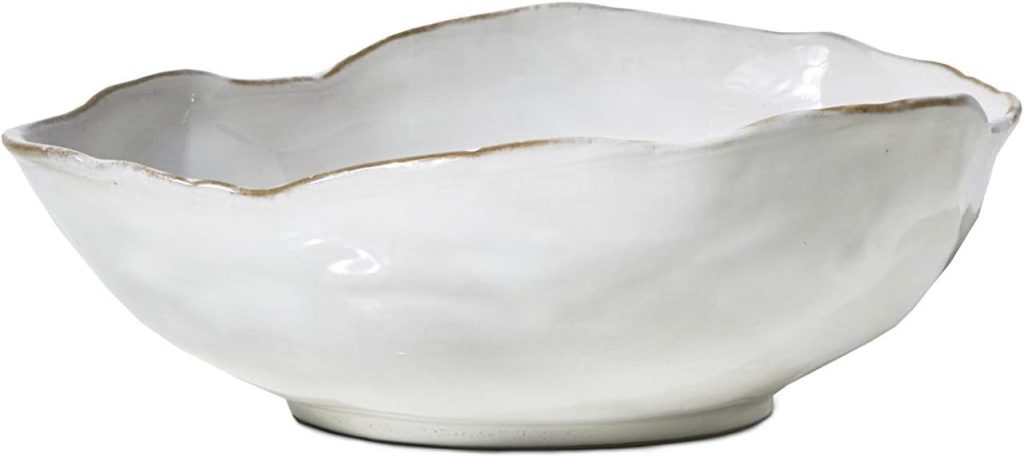 White ceramic bowl with an irregular, scalloped edge and a slightly wavy, textured surface, shown against a plain background.