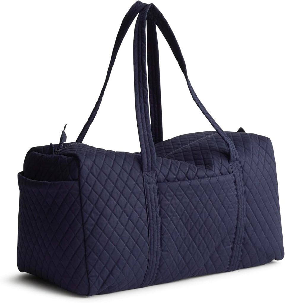 A navy blue quilted duffel bag with two long handles and an exterior side pocket is shown against a white background.