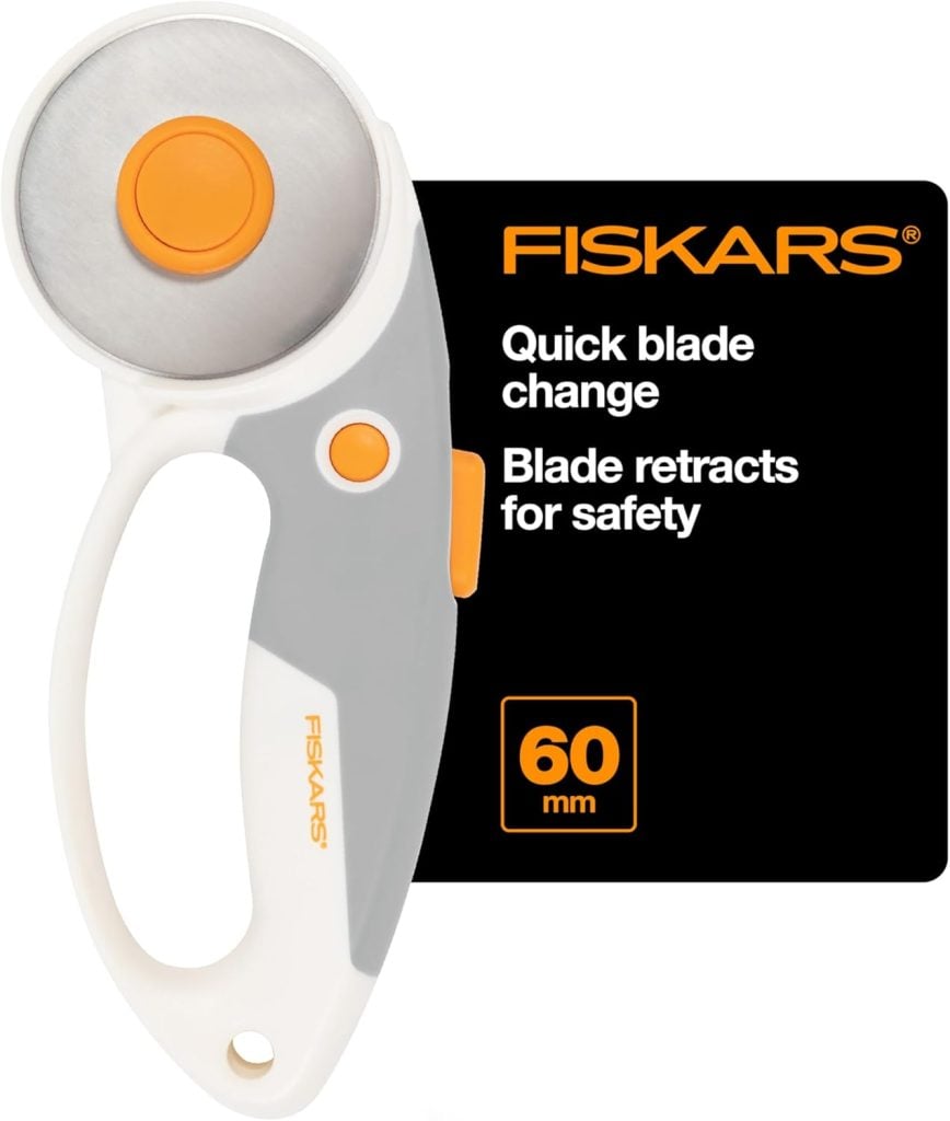 Fiskars 60mm rotary cutter with retractable blade, featuring an ergonomic handle and quick blade change, displayed next to product information.