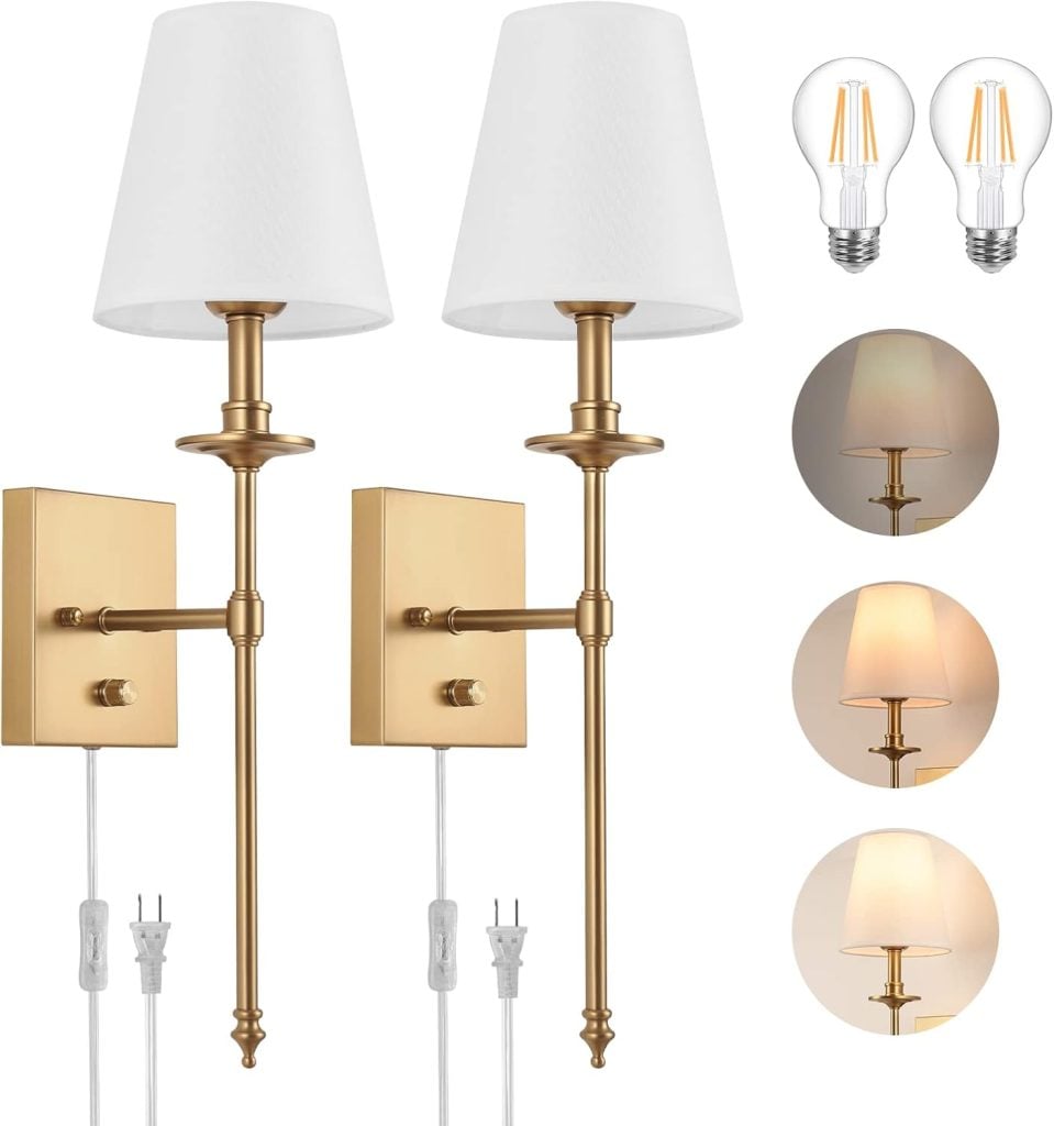 A pair of gold wall sconces with white lampshades, two light bulbs, and examples of different lighting tones. Each sconce has a white cord with a plug.