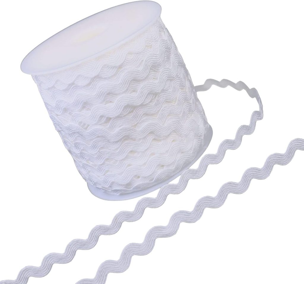 A spool of white rickrack trim with a wavy pattern, with a length of the trim extending from the spool.