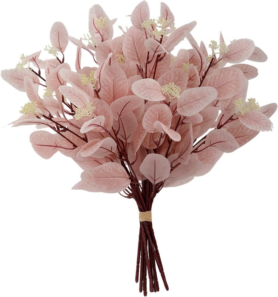 A bouquet of artificial pink leaves with small white flowers, tied with a rubber band at the stems.