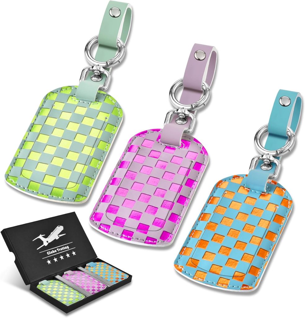 Three woven-pattern luggage tags in green, pink, and orange-blue with leather straps, displayed above a black gift box with a travel-themed design.