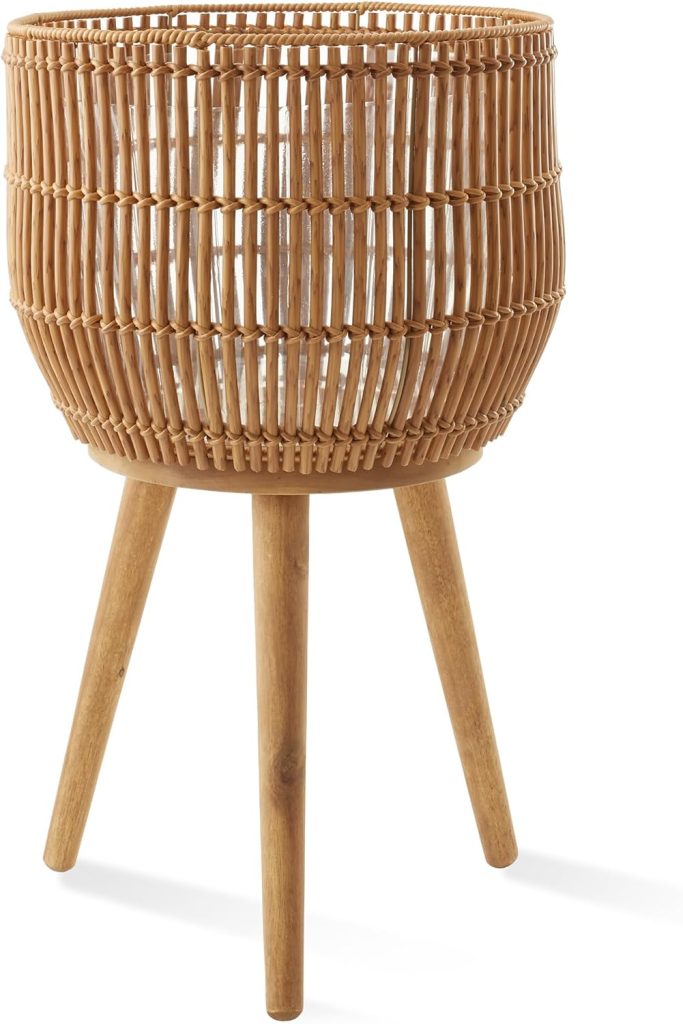 Three-legged wooden plant stand with a round, woven rattan basket on top, designed for indoor use—a stylish piece that beautifully complements other rattan furniture in your home.