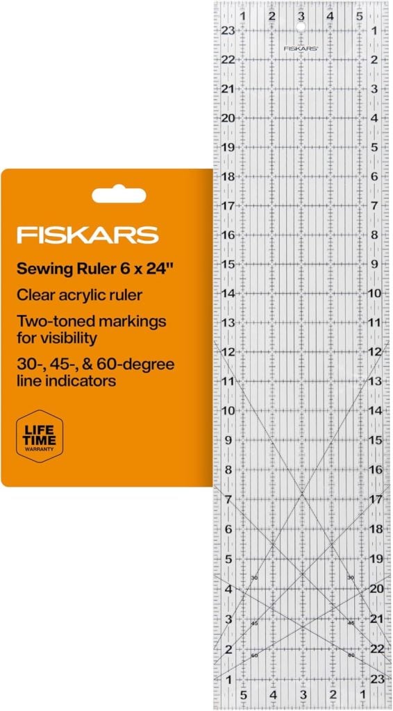 Fiskars clear acrylic sewing ruler, 6 x 24 inches, with two-toned markings and 30°, 45°, and 60° line indicators; packaging notes a lifetime warranty.