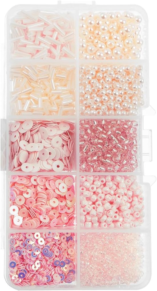 Plastic organizer box with eight compartments containing assorted pale pink, white, and peach beads and sequins in different shapes and sizes.