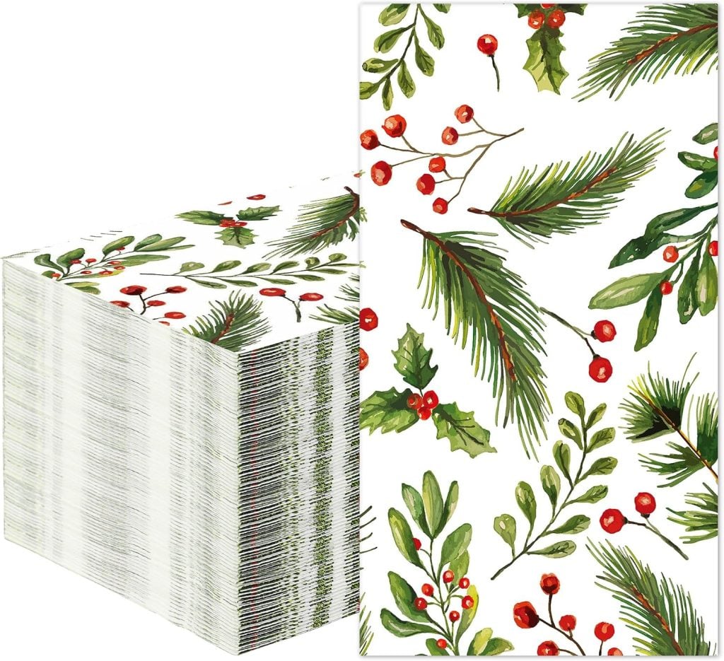 Stack of rectangular paper napkins with a white background and a festive botanical print featuring green pine branches, holly leaves, and red berries—perfect for adding a seasonal touch to your table setting or inspiring creative paper napkin crafts.