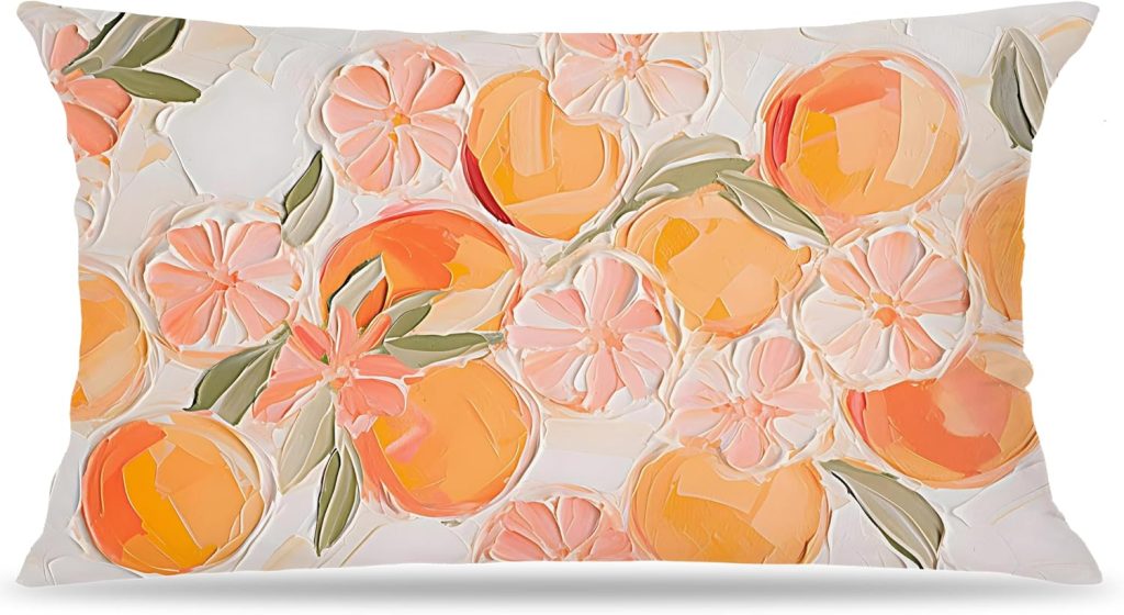 Rectangular pillow with a painted pattern of orange fruit, green leaves, and pink flowers on a white background.