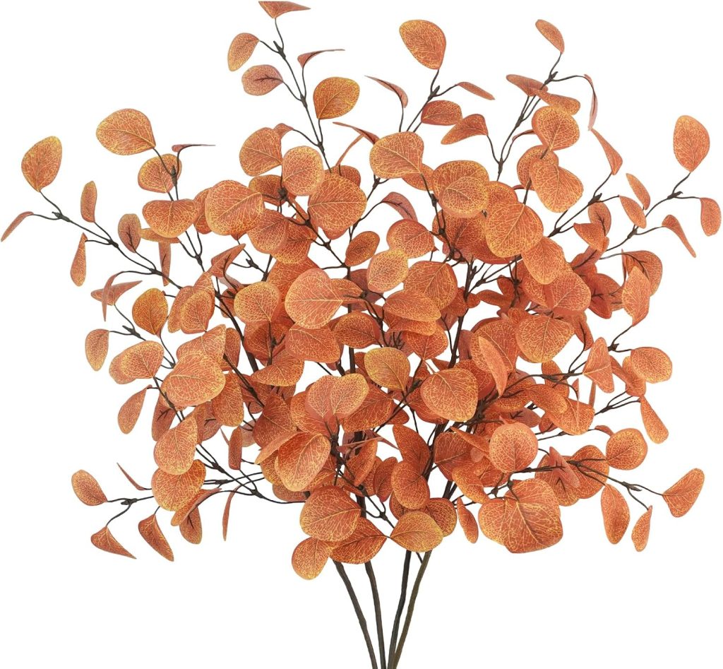 Cluster of artificial branches with orange, round leaves against a white background.