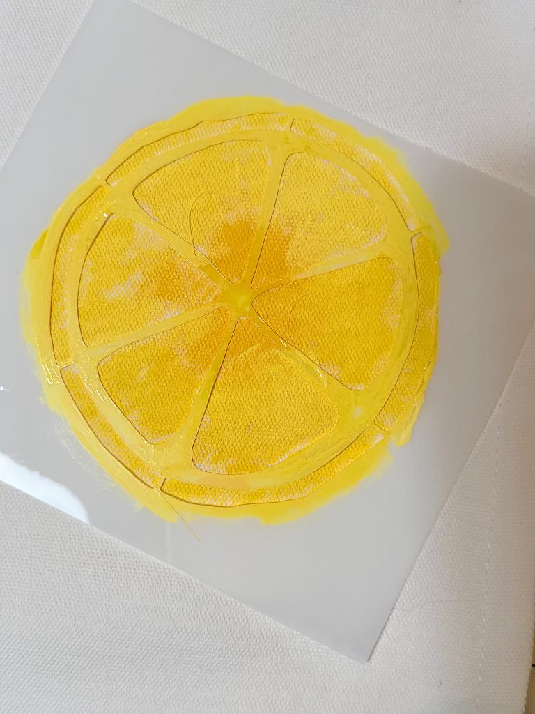 A yellow, painted lemon slice with six segments on a white, textured background.