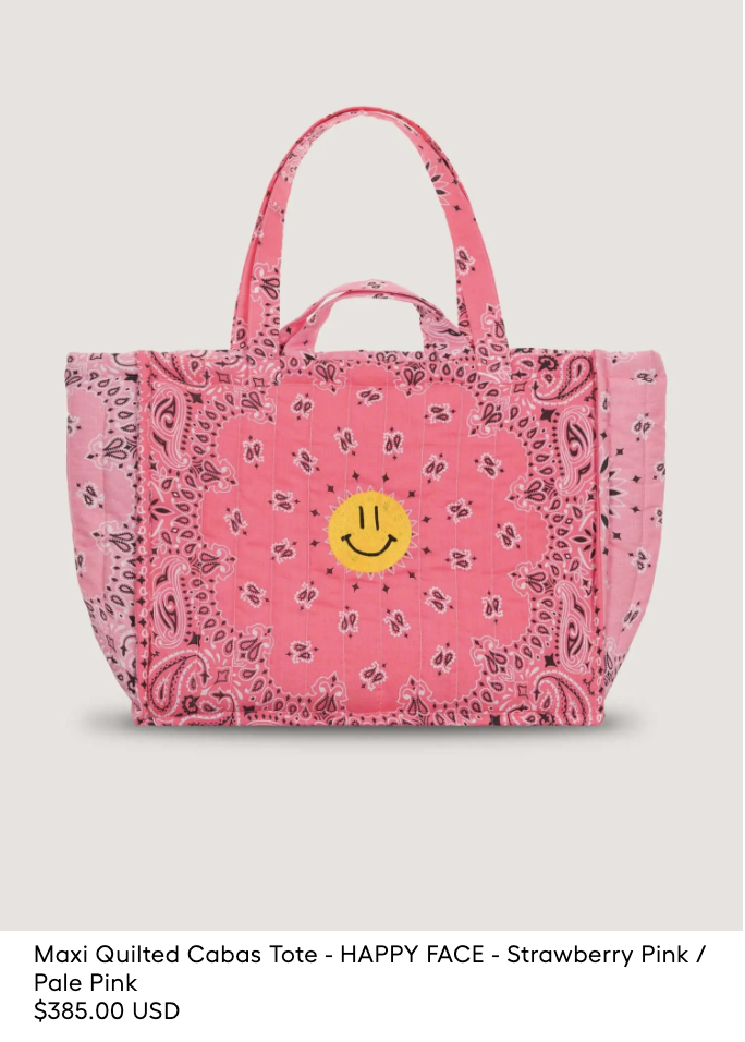A large pink quilted tote bag with a bandana pattern and a yellow smiley face patch in the center. Price: $385.00 USD.