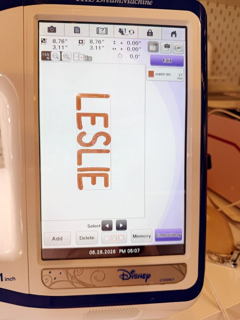 Embroidery machine screen displays the name "LESLIE" in red, vertically oriented, with various settings and options visible around the design.